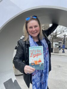 Author standing in the Ottawa sign "O" holding her debut book